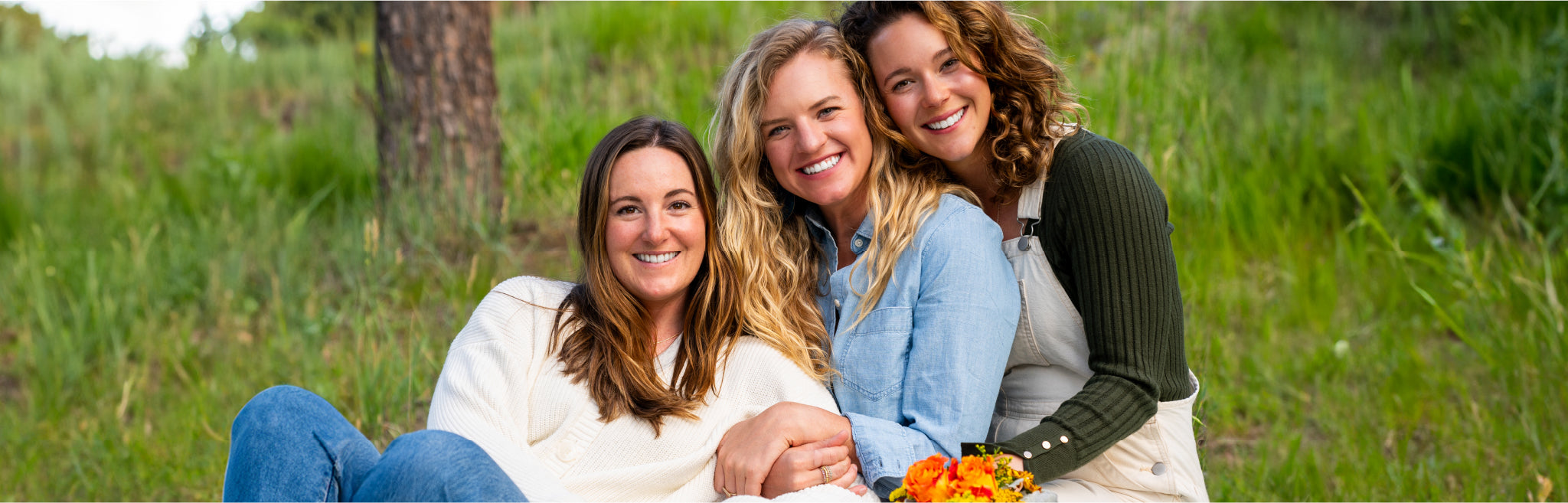 A picture of Loona Seeds founders Emily Cohen, Carly Schaller, and Abby Rogers leaning against each other and smiling at the camera.