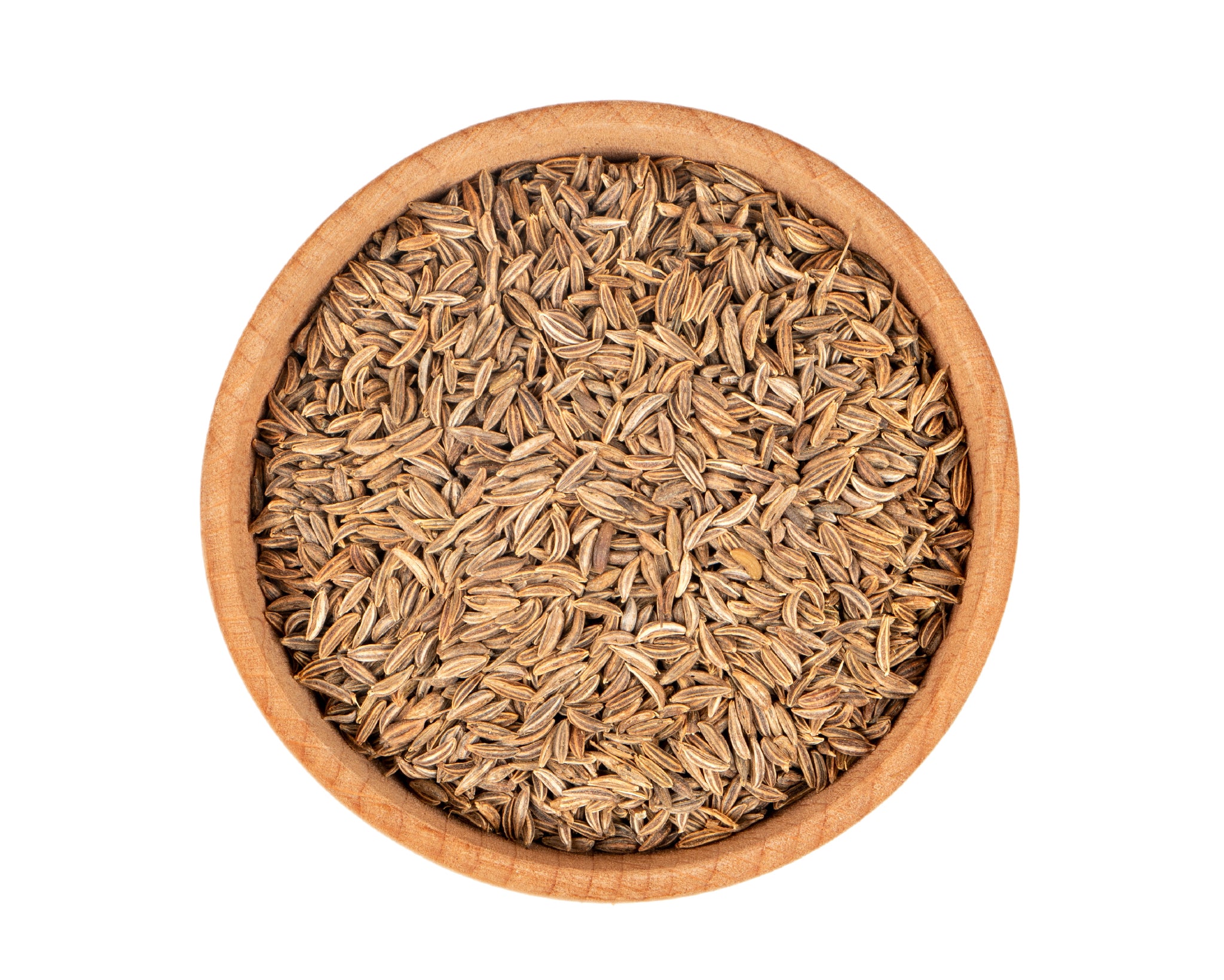 A small wooden bowl filled with caraway seeds, on a white background with seeds scattered around it.