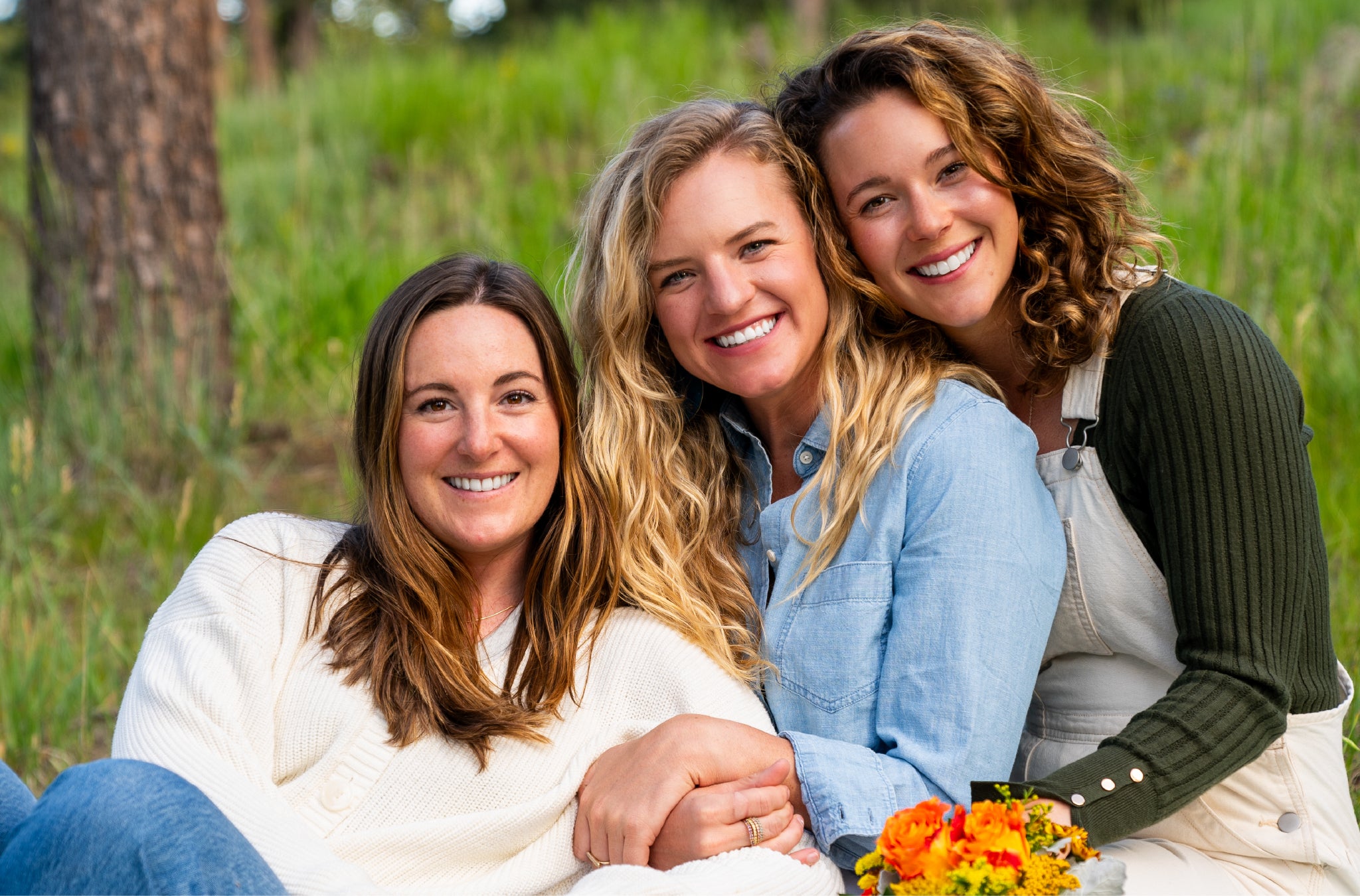 A picture of Loona Seeds founders Emily Cohen, Carly Schaller, and Abby Rogers leaning against each other and smiling at the camera.